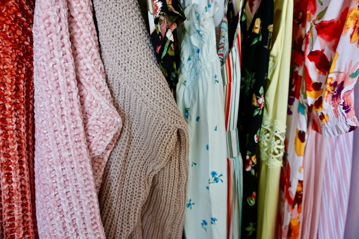 Colorful clothing items hanging on a clothing rack.